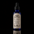 A 2 oz cobalt blue glass dropper bottle of St. Aries Citrus Hair & Scalp Oil, featuring a cream-colored label with black text and a ram illustration, set against a solid black background with a reflection below.